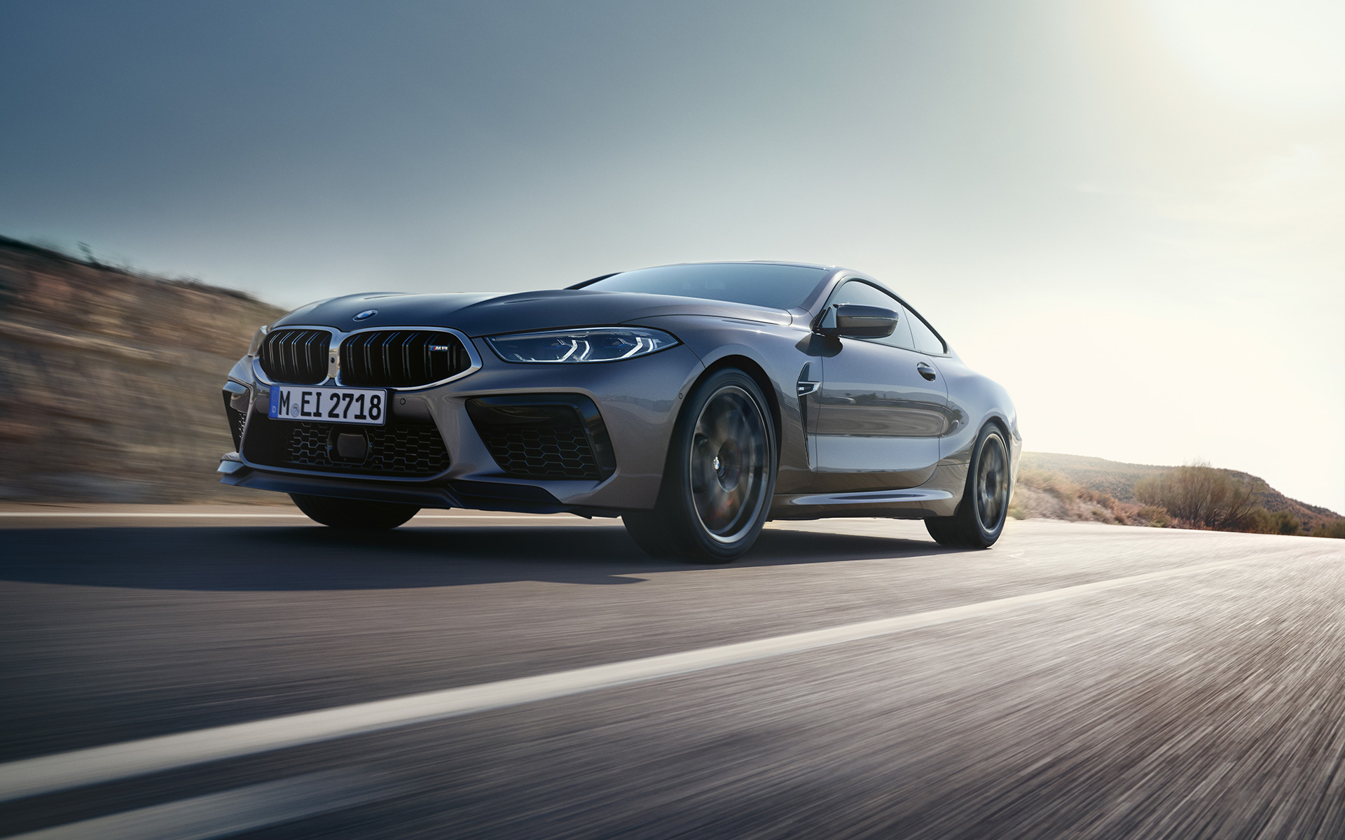 BMW M8 Coupé, F92, LCI, osvežitev 2022, kovinska barva Skyscraper Grey, tričetrtinski pogled od spredaj med vožnjo po avtocesti, posnetek pod nizkim kotom